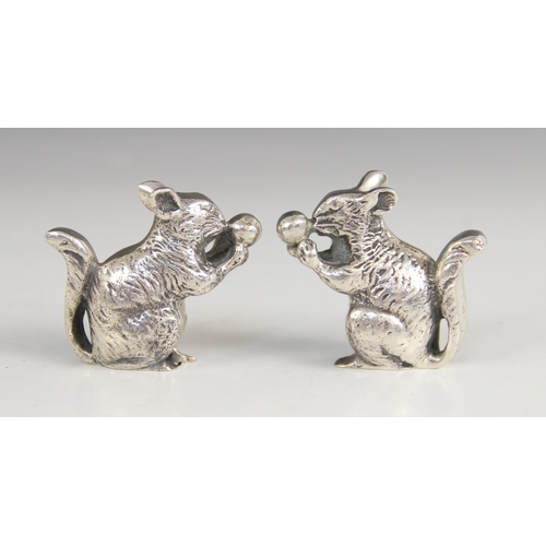 30 - A pair of continental silver squirrel figures, each modelled resting on hind legs eating a nut with ... 