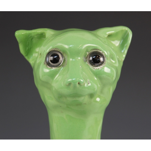 388 - A stoneware model of a cat, 20th century, in the manner of Galle, glazed in green with colourless gl... 