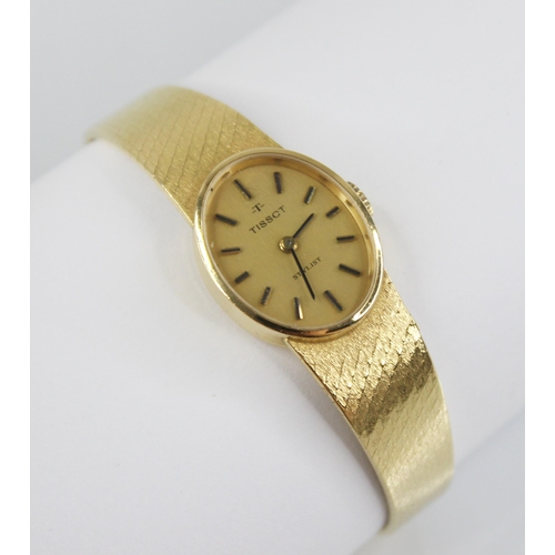 49 - A lady's Tissot Stylist 18ct gold wristwatch, the brushed gold coloured oval dial with baton markers... 
