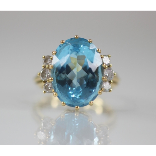 62 - A blue topaz and diamond cocktail ring, the oval mixed cut topaz measuring 16mm x 12mm x 8.5mm, with... 