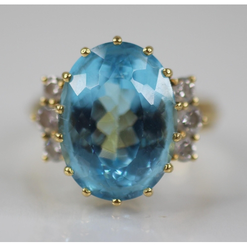 62 - A blue topaz and diamond cocktail ring, the oval mixed cut topaz measuring 16mm x 12mm x 8.5mm, with... 