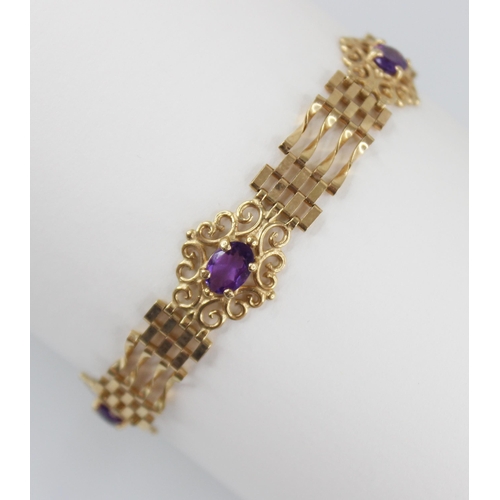 95 - A gold coloured amethyst set bracelet, the gate-link bracelet interspersed by three pierced scrollin... 