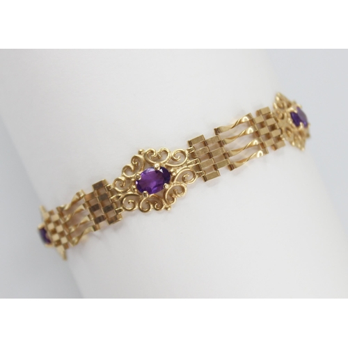 95 - A gold coloured amethyst set bracelet, the gate-link bracelet interspersed by three pierced scrollin... 