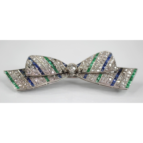 97 - An Art Deco diamond, sapphire and emerald bow brooch, the central round old cut diamond weighing app... 