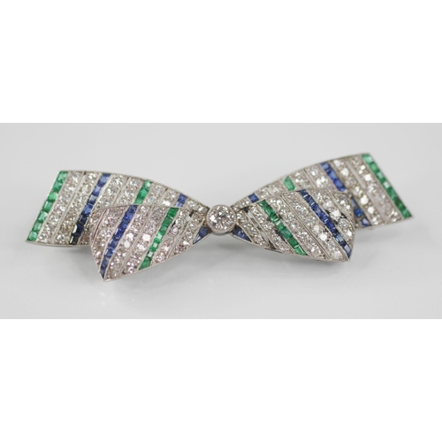 97 - An Art Deco diamond, sapphire and emerald bow brooch, the central round old cut diamond weighing app... 