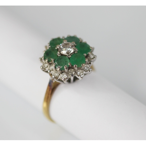 98 - An emerald and diamond floral cluster ring, the central round brilliant cut diamond with a 0.35 cara... 