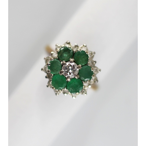 98 - An emerald and diamond floral cluster ring, the central round brilliant cut diamond with a 0.35 cara... 