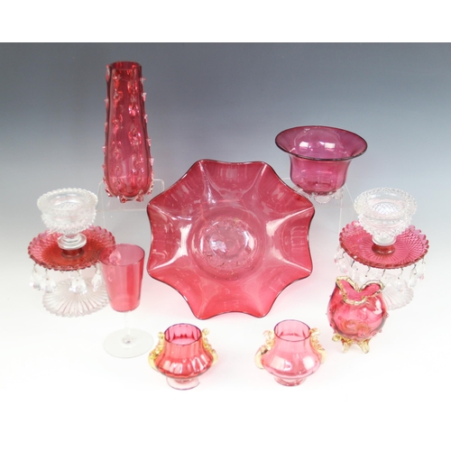 405 - A pair of Victorian cranberry and clear glass table lustres, each upon a petal cut base, supporting ... 