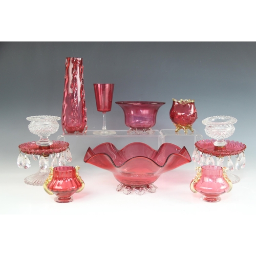 405 - A pair of Victorian cranberry and clear glass table lustres, each upon a petal cut base, supporting ... 