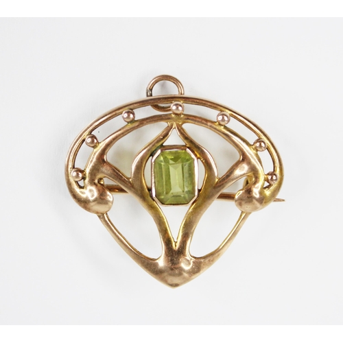 61 - An Art Nouveau peridot set brooch/pendant, the central rectangular step cut peridot measuring 7.2mm ... 