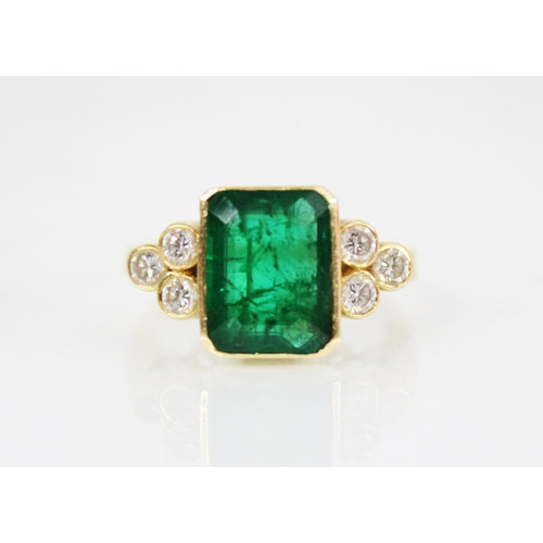 121 - An emerald and diamond 18ct gold ring, the central rectangular step cut emerald with canted corners ... 