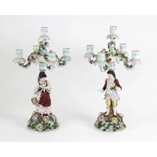 385 - A pair of continental porcelain five branch figural candelabra, late 19th century, one modelled with... 