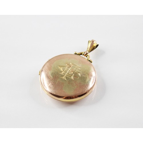 59 - An Edwardian 9ct gold locket pendant, of circular form with monogrammed initials to cover, opening t... 
