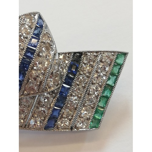 97 - An Art Deco diamond, sapphire and emerald bow brooch, the central round old cut diamond weighing app... 