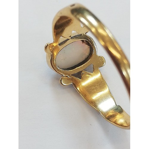 125 - An early 20th century opal 18ct gold ring, the central oval opal cabochon measuring 7.5mm x 5mm, bez... 