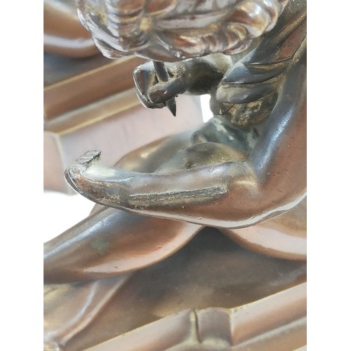 157 - A pair of French bronze bookends, early 20th century, each modelled as a scribing cherub, each 11.5c... 