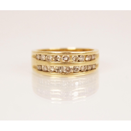 104 - A diamond 18ct gold ring, comprising two rows of graduated round brilliant cut diamonds, channel set... 