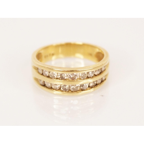 104 - A diamond 18ct gold ring, comprising two rows of graduated round brilliant cut diamonds, channel set... 