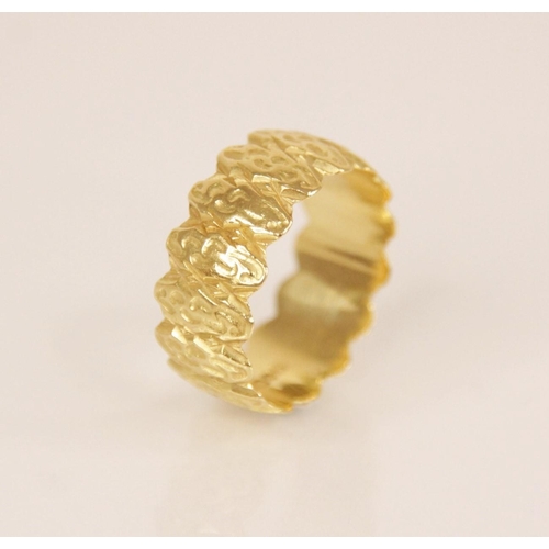 105 - An 18ct gold dress ring, the textured band with scalloped borders, marks for MS&S London (date lette... 