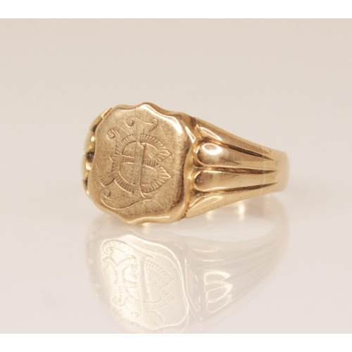 113 - An Edwardian 9ct gold signet ring, the shield shaped head with monogrammed initials, set to reeded t... 