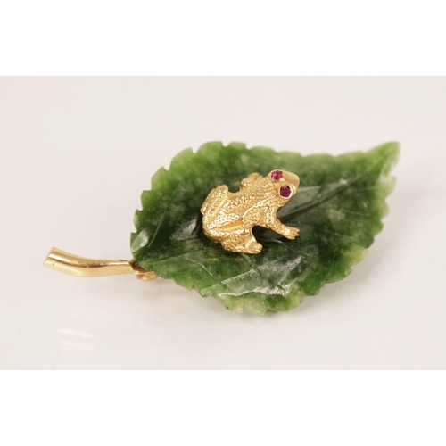 127 - An Italian novelty brooch by Cellino, modelled as a frog with ruby set eyes, sat upon a carved nephr... 