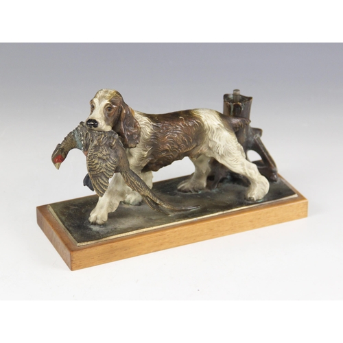 173 - An Austrian cold painted spelter table top lighter, 20th century, modelled as a spaniel retrieving a... 