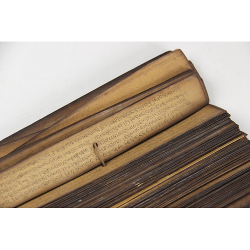 247 - A palm leaf manuscript, probably south Asian, comprising approximately one hundred leaves (most with... 