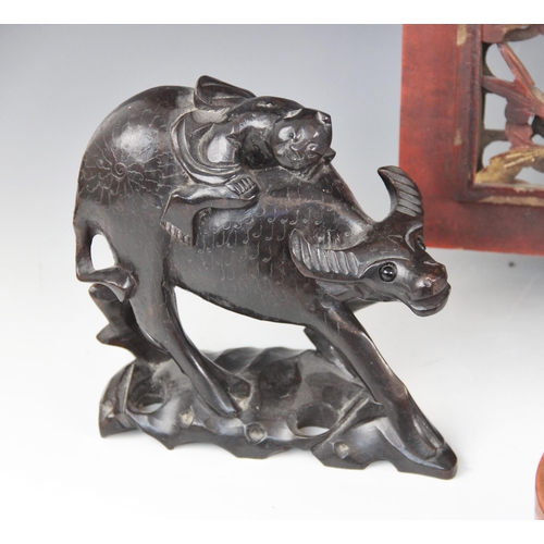 413 - A pair of Chinese hardwood models of water buffalo and riders, each 18cm high, with an oriental pier... 