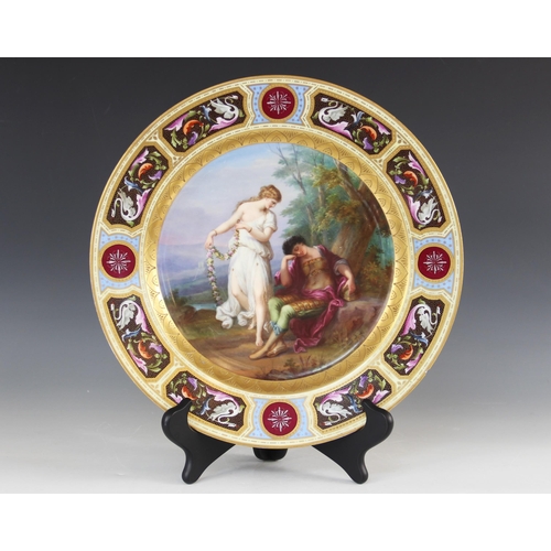 437 - A late 19th century continental porcelain painted charger, the centre depicting a sleeping Mars and ... 