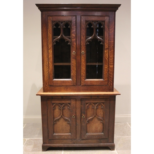 793 - A Victorian oak Gothic library bookcase, the moulded cornice above a pair of glazed doors applied wi... 