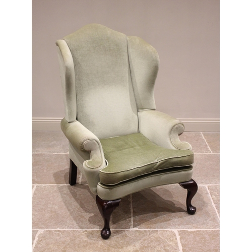 801 - A Queen Anne style wing back armchair, mid 20th century, in green velour, the arched back extending ... 