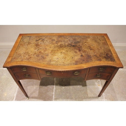 807 - An Edwardian mahogany serpentine writing desk, in the manner of Maple & Co, the leather skiver inset... 