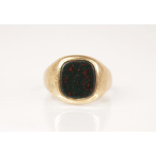 87 - A bloodstone set 9ct gold signet ring, the central rounded square matrix measuring 10.2mm x 9.6mm, s... 