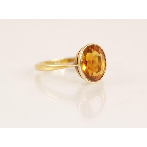 158 - An early 20th century 18ct gold yellow gemstone set dress ring, the central oval mixed cut yellow ge... 