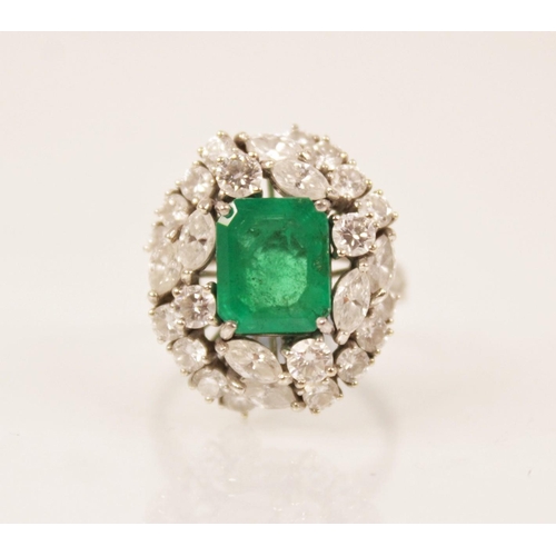 159 - An emerald and diamond ring, the central rectangular step cut emerald measuring 9.7mm x 8.0mm, set t... 