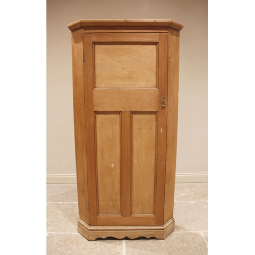 797 - A Victorian pine freestanding corner cupboard, the moulded cornice above a single tri-panelled door,... 