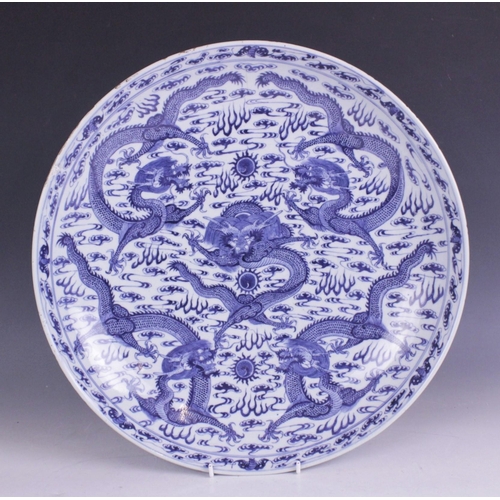 408 - A large Chinese porcelain blue and white 'Dragon' charger, Kangxi mark, the shallow circular charger... 