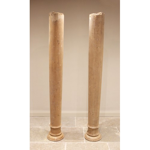 775 - A pair of architectural pine columns, each of tapering cylindrical form, with circular capitals abov... 