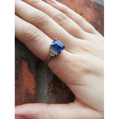 151 - An Art Deco sapphire and diamond ring, the central rectangular emerald cut cornflower blue sapphire ... 