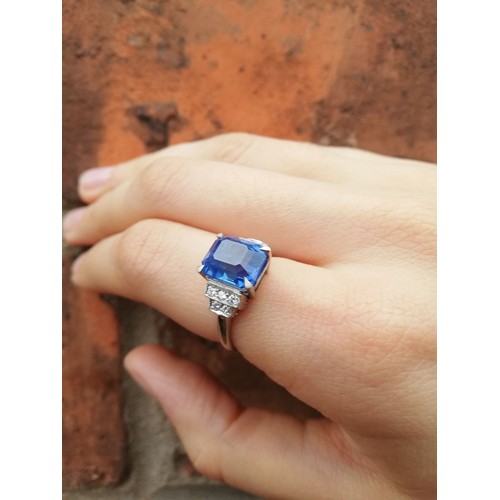 151 - An Art Deco sapphire and diamond ring, the central rectangular emerald cut cornflower blue sapphire ... 