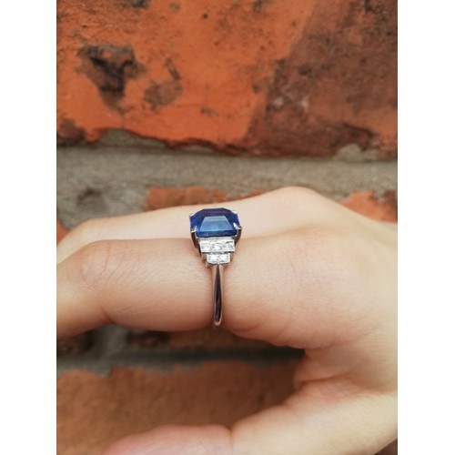 151 - An Art Deco sapphire and diamond ring, the central rectangular emerald cut cornflower blue sapphire ... 