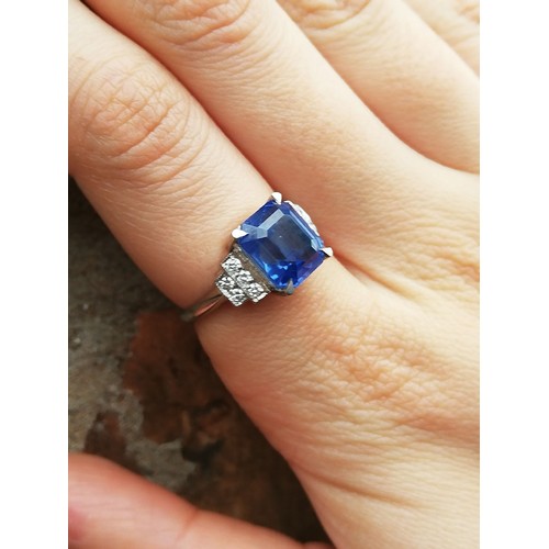 151 - An Art Deco sapphire and diamond ring, the central rectangular emerald cut cornflower blue sapphire ... 