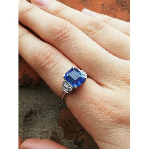 151 - An Art Deco sapphire and diamond ring, the central rectangular emerald cut cornflower blue sapphire ... 