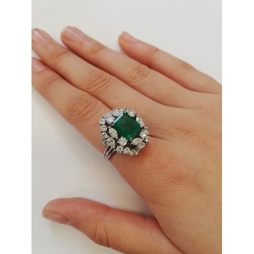 159 - An emerald and diamond ring, the central rectangular step cut emerald measuring 9.7mm x 8.0mm, set t... 