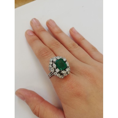 159 - An emerald and diamond ring, the central rectangular step cut emerald measuring 9.7mm x 8.0mm, set t... 