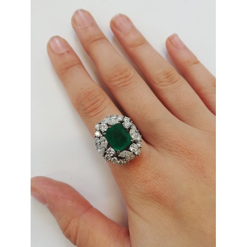 159 - An emerald and diamond ring, the central rectangular step cut emerald measuring 9.7mm x 8.0mm, set t... 