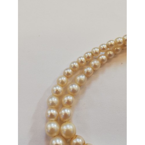 129 - A cultured pearl choker with diamond set clasp, comprising two rows of off-round cultured pearls, me... 