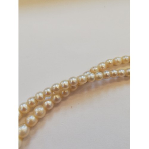 129 - A cultured pearl choker with diamond set clasp, comprising two rows of off-round cultured pearls, me... 