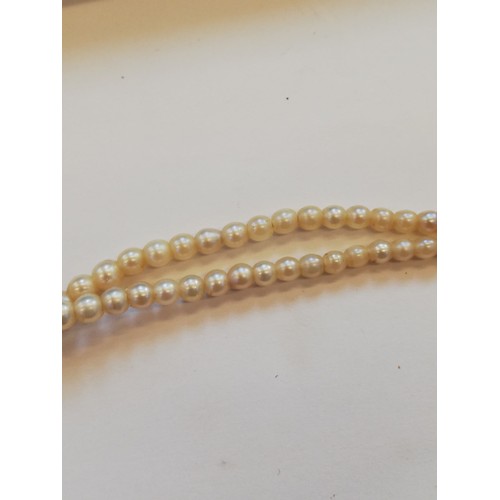 129 - A cultured pearl choker with diamond set clasp, comprising two rows of off-round cultured pearls, me... 