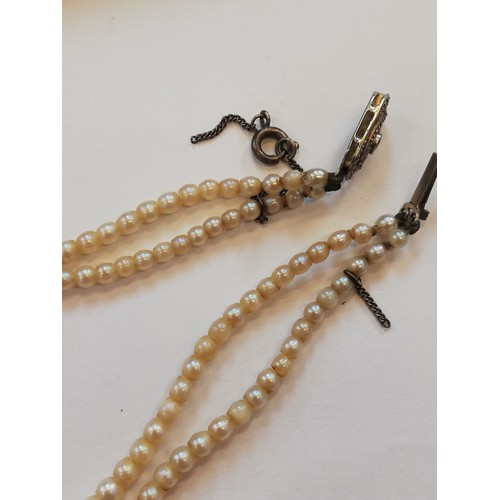 129 - A cultured pearl choker with diamond set clasp, comprising two rows of off-round cultured pearls, me... 